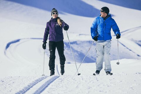Zwei Langläufer auf einer verschneiten Strecke