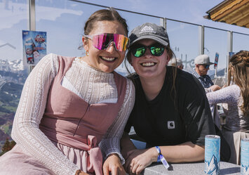 Zwei Frauen mit Sonnenbrillen posieren für ein Foto.