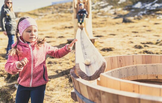 Kinder spielen mit einer Holzkugelbahn