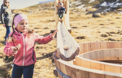Kinder spielen mit einer Holzkugelbahn