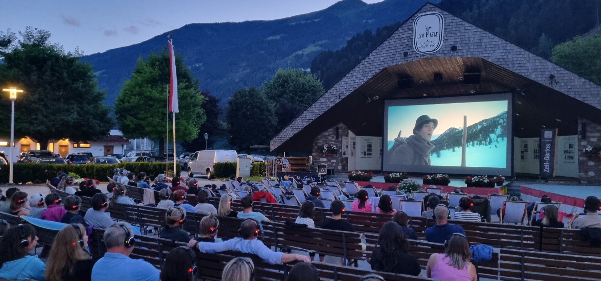 Sommerkino in Zell am Ziller am Musikpavillon, mit einem Film und einer Gruppe von Menschen auf Bänken