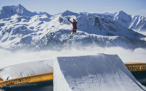 Ein Skifahrer fährt auf einer großen Rampe.