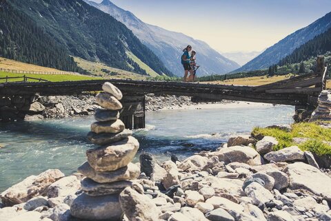 Zwei Frauen gehen über eine Holzbrücke