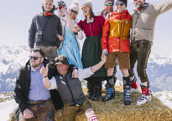 Eine Gruppe Menschen sitzt auf einem Heuballen.