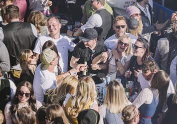 Junge Menschen in Tracht feiern zusammen im Freien..