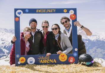 Eine Gruppe posiert mit einem Bilderrahmen im Schnee.