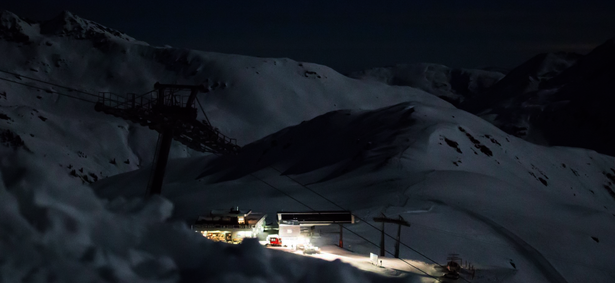 [Translate to NL:] Blick auf eine verschneite Piste bei Nacht.