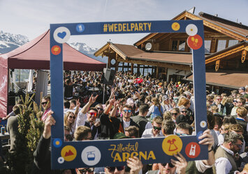 Eine Menschengruppe posiert mit einem Bilderrahmen im Freien.