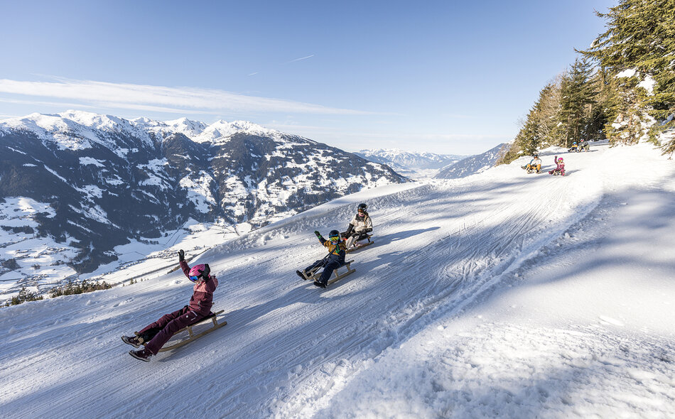 Rodler fahren die Strecke hinunter