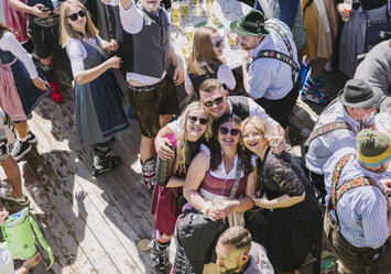 Ein Mann und drei Frauen in Tracht lächeln in die Kamera. 