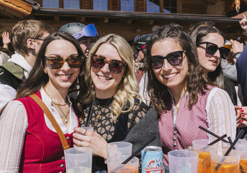 Drei Frauen mit Sonnenbrillen lachen in die Kamera.