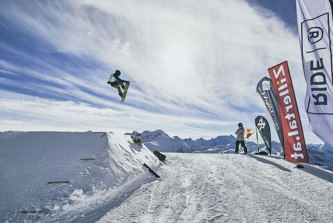 Ein Snowboarder macht einen Sprung auf der Piste