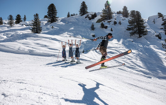 eine Gruppe in Tracht beim Skifahren