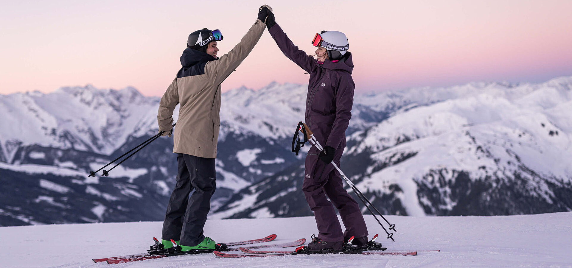 Zwei Skifahrer geben sich ein High-Five auf der Piste