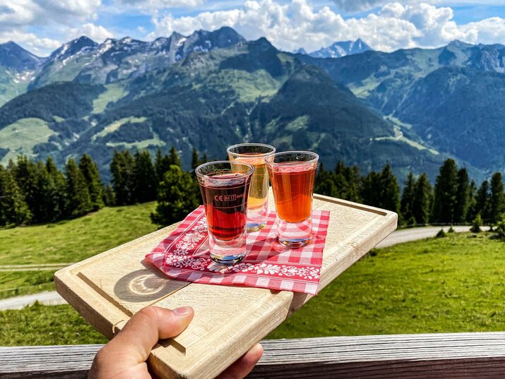 Drei gefüllte Shotgläser vor einer traumhaften Bergkulisse