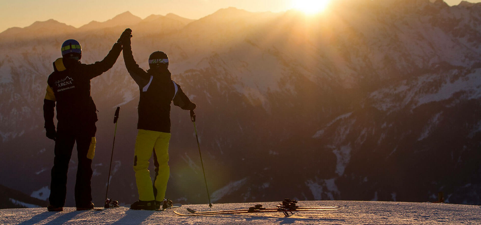 Zwei Skifahrer beobachten den Sonnenaufgang