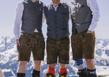 Drei Männer in Trachtenkleidung posieren für ein Foto.