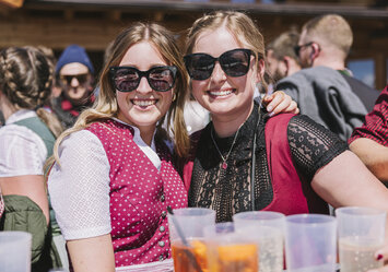 Zwei Frauen mit Sonnenbrillen posieren für ein Foto.