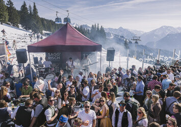 Im Freien spielt eine Band Musik für zahlreiche Zuschauer.