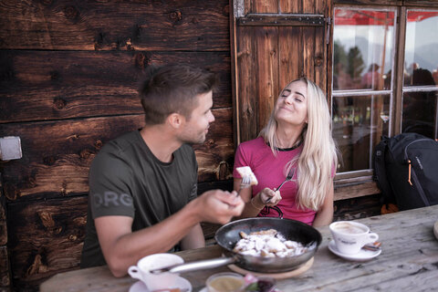 Ein Mann und eine Frau teilen sich einen Kaiserschmarrn