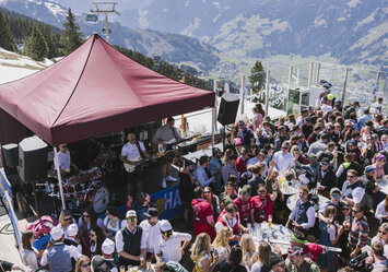 Eine Gruppe von Menschen feiern vor einem Haus.