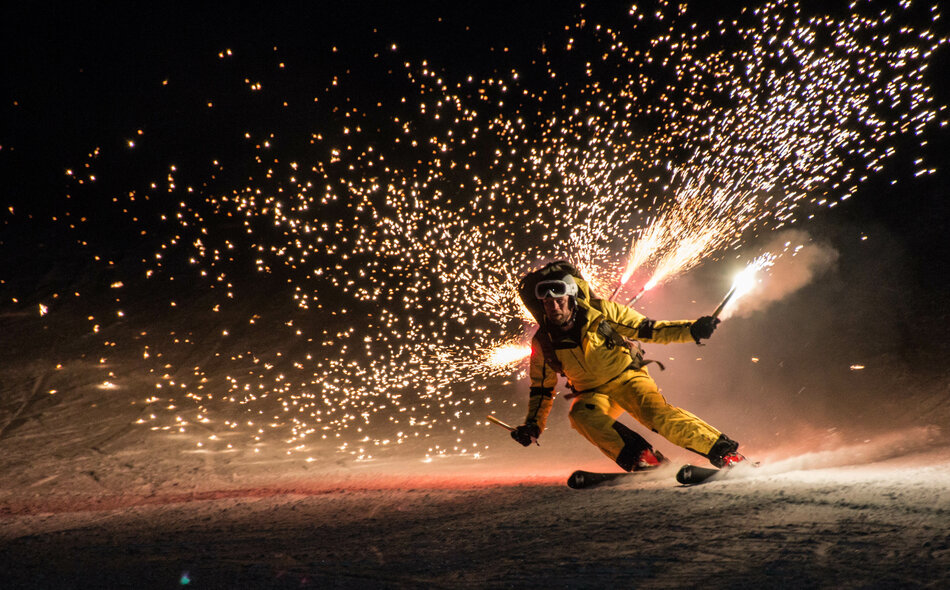 Ein Mann führt eine leuchtende Ski Show auf.