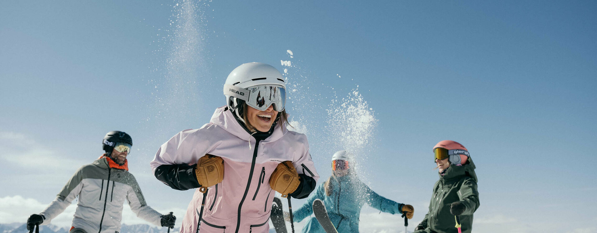 Vier Skifahrer drei haben einen Skier in der Luft
