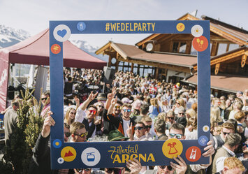 Eine große Menschgruppe macht ein Foto mit einem Bilderrahmen.