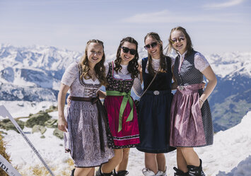 Vier Frauen in Dirndln posieren für ein Foto.