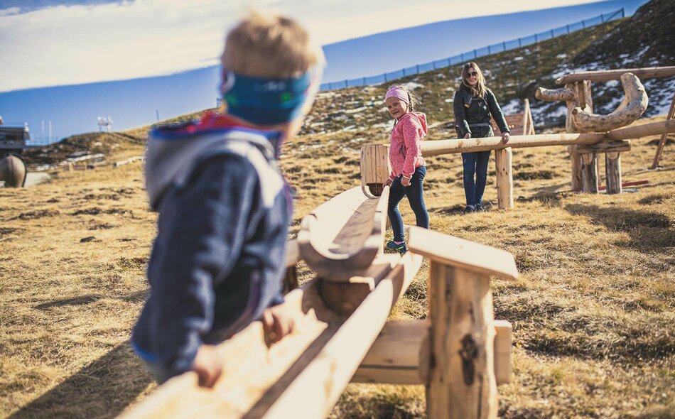 Kinder spielen mit einer Holzkugelbahn