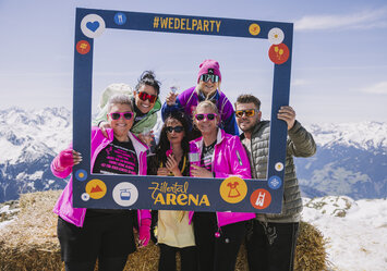 Sechs Personen posieren mit einem Bilderrahmen für ein Foto.