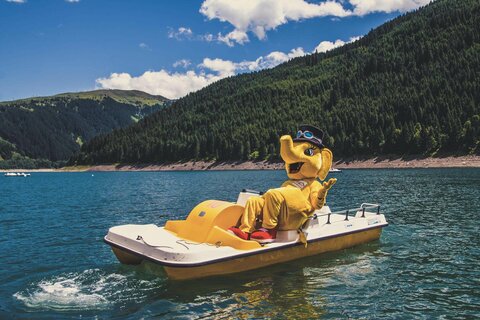 Das Maskottchen Funty fährt Tretboot auf dem Stausee