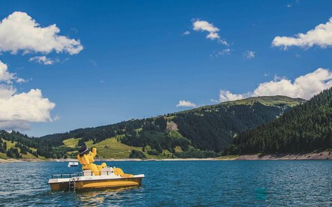 Das Maskottchen Funty fährt Tretboot auf dem Stausee