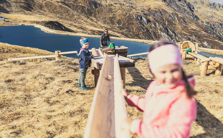 Kinder spielen mit einer Holzkugelbahn