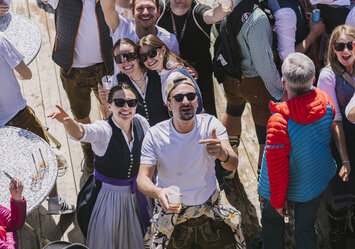 Eine Gruppe von Menschen in Trachtenkleidung feiern zusammen im Freien.