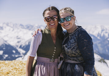 Zwei Frauen mit Sonnenbrillen posieren für ein Foto.
