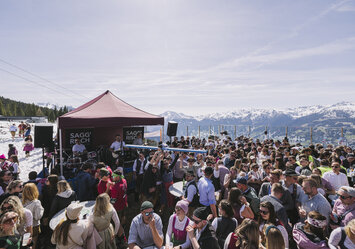 Eine große Gruppe von Menschen feiern und trinken zusammen im Freien.