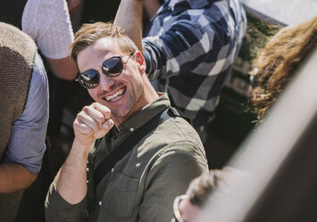 Ein Mann mit Sonnenbrille lächelt in die Kamera.