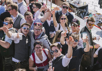 Junge Menschen in Tracht lächeln in die Kamera.