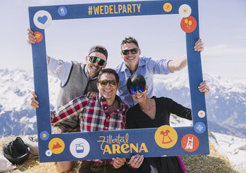 Drei Männer und eine Frau posieren für ein Foto mit einem Bilderrahmen.