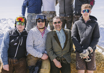 Eine Gruppe von Männern posieren für ein Foto auf einem Heuballen.
