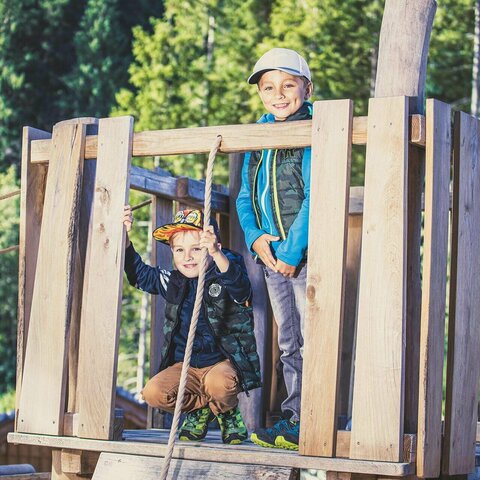 Zwei Jungs sitzen auf einem Baumhaus