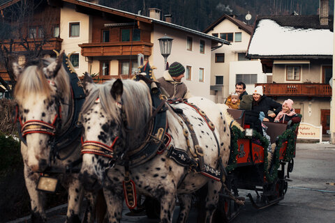 Eine Familie fährt mit einer Pferdekutsche.