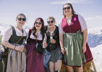 Vier Frauen in Tracht posieren für ein Foto.