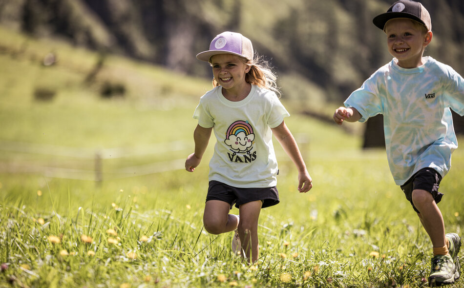 Kinder rennen durch die Wiese.