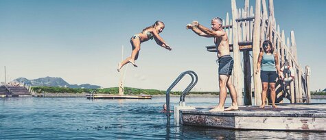 Mann wirft kleines Mädchen ins Wasser.