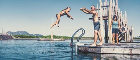 Mann wirft kleines Mädchen ins Wasser.