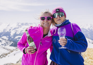 Zwei Frauen trinken zusammen Bier und Wein.