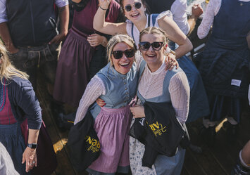 Drei Frauen in Dirndln lächeln in die Kamera.