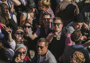 Mehrere Personen lächeln und zeigen in die Kamera.